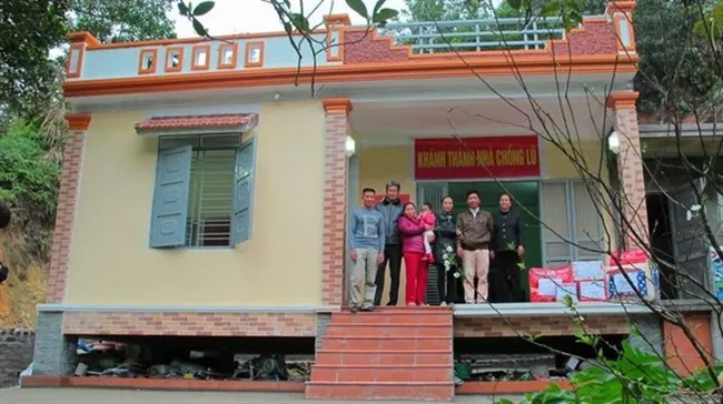 A needy family pose in front of their newly built flood-resistant house in T​an H​oa Commune, Minh H​oa District, Qu​ang B​inh Province. (Photo courtesy of NCM)