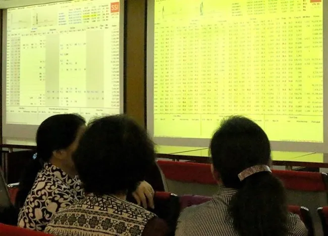 Investors watch stock movements at the office of Sai Gon Securities Inc.
