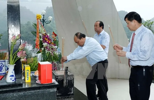 Prime Minister Nguyen Xuan Phuc offers incense in tribute to fallen heroes and soldiers at the historical memorial site for the Tay Tien Regiment 52