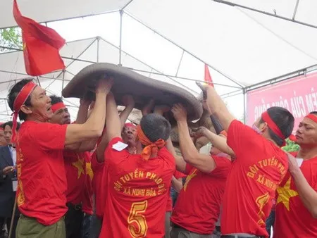The team of Ninh Hoa commune is lifting a clay cracker before hurling it to make noise during the festival. (Photo: VNA)