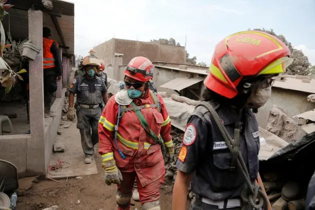 Rescue workers inspect an area affected by the eruption of the Fuego volcano in the community of San Miguel Los Lotes in Escuintla, Guatemala June 5, 2018. REUTERS/Luis Echeverria