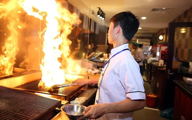 A chef is preparing food for customers.