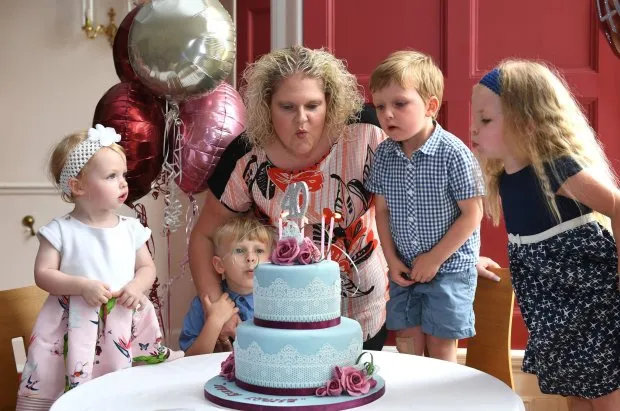 Louise Brown, the world’s first test tube baby, blows out candles on a 40th birthday cake with her son Aiden and IVF babies (left to right) (Picture: PA)