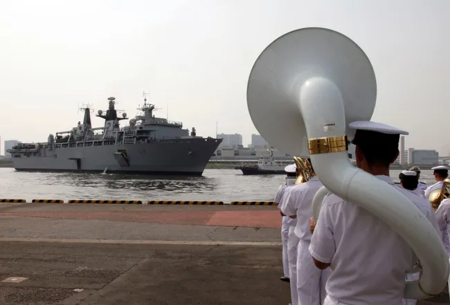 Japan Self-Defense Forces marching band members perform as British Royal Navy’s HMS Albion amphibious assault ship arrives at a dock in Tokyo Friday, Aug. 3, 2018. (Photo: (Ken Moritsugu/Associated Press)