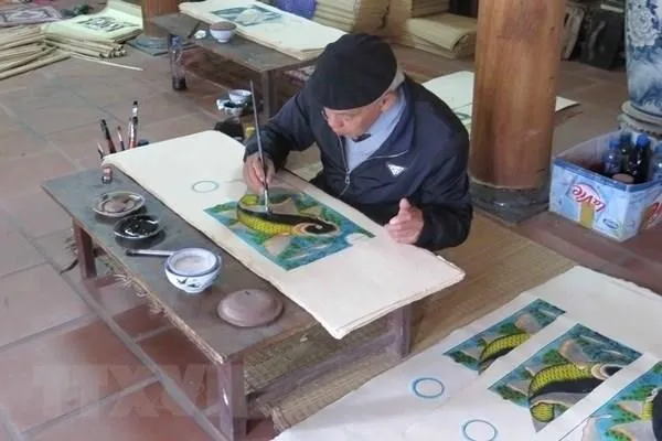 An artisan finishes a Dong Ho painting (Photo: VNA)