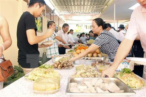 Vietnamese people enjoy traditional foods to welcome the New Year at the Vietnamese Embassy in Angola. (Photo: VNA)