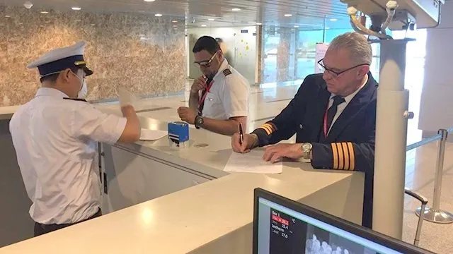 A staff member at Da Nang International Airport checks the temperature of incoming passengers.