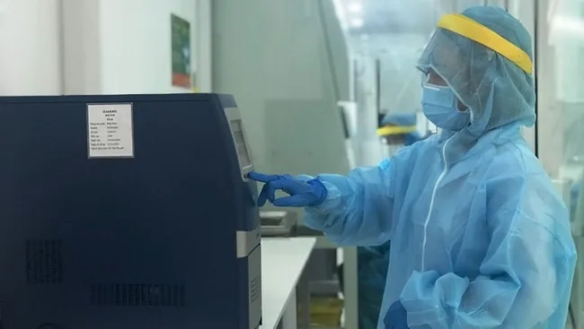 A lab technician operates a COVID-19 testing machine at Thien Nhan Da Nang Laboratory. (Photo: NDO/Anh Dao)