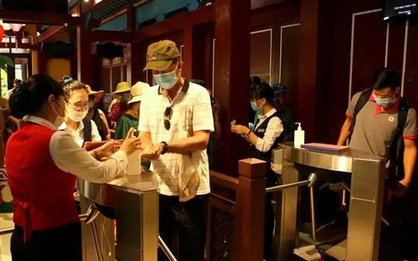 Visitors wash hands with sanitiser before entering the Ba Na Hills tourism complex in Da Nang. (Photo: VNA)