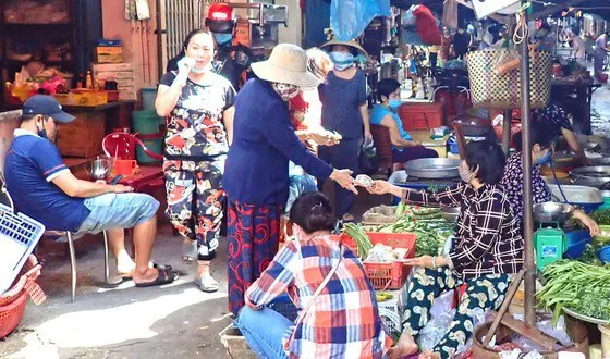 Some people at Ban Co Market in HCM City’s District 3 wear their face masks improperly (Photo: courtesy of www.sggp.org.vn)