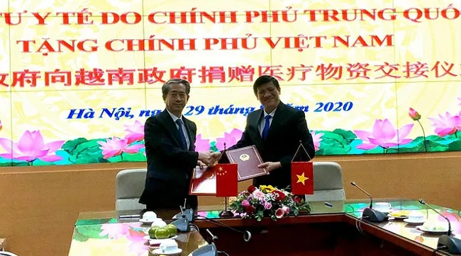 Acting Minister of Health Nguyen Thanh Long (R) and Chinese Ambassador to Vietnam Xiong Bo sign the minutes of the handover. (Photo: Ministry of Health)