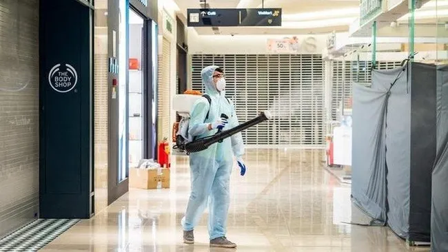 A medical worker sprays disinfectant