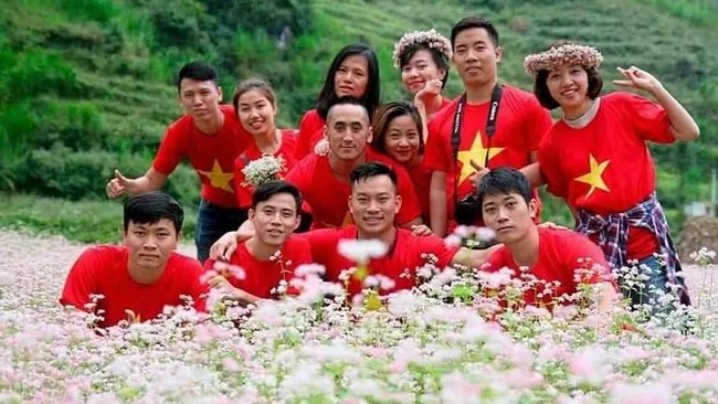 Visitors pose for a group photo amid a buckwheat flower filed in Ha Giang Province