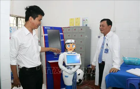Vo Hong Quan, Director of the Centre of Information and Technology of the Eastern People Military Hospital in HCM City (left), introduces the nurse robot named Tam. (Photo:VNA)