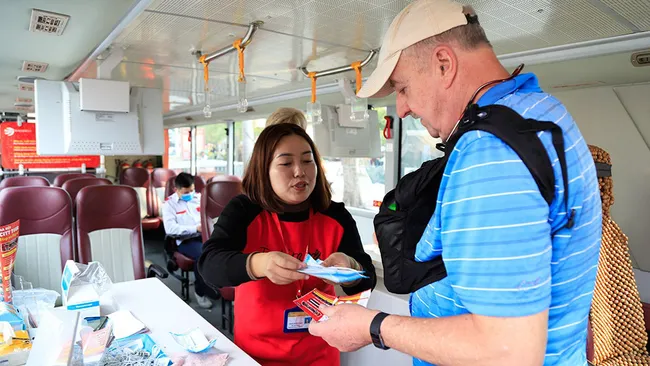 Visitors on double-decker city tour buses around Hanoi are being provided with free medical masks to protect themselves from coronavirus threat (Photo: hanoimoi.com.vn)