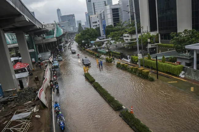 Vehicles move slowly on a flooded Jl. Rasuna Said in Kuningan, Jakarta, on Tuesday. Heavy rain since Monday morning has left numerous areas of the capital flooded. (Photo: thejakartapost.com)