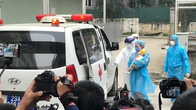 The three-month-old coronavirus patient, carried by her mother, is discharged from hospital after being successfully treated by doctors at the National Children’s Hospital. (Photo: NDO/Thien Lam)