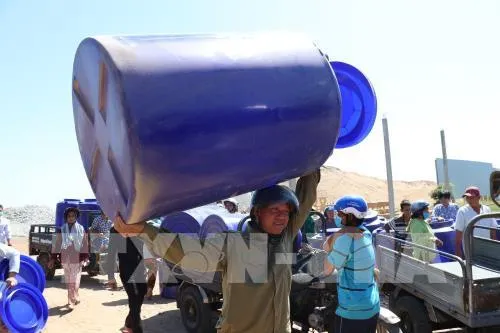 People in the areas hit by drought and saline intrusion in the Mekong Delta province of Ben Tre is presented with water tanks and supplied with fresh water. (Photo: VNA)