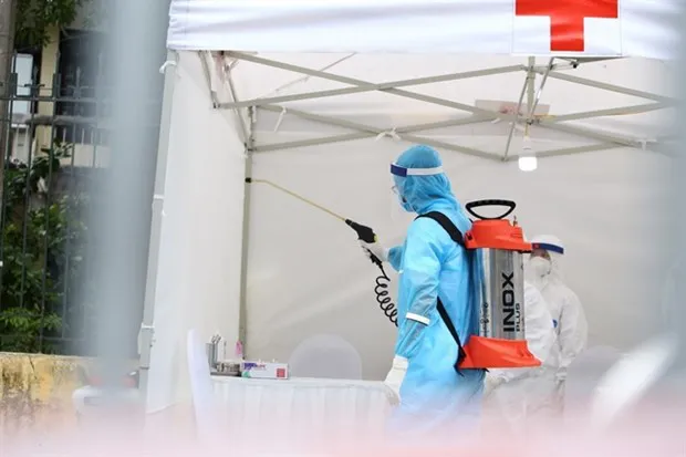 A medical worker sterilises a COVID-19 quick test station in Hanoi on March 31. (Photo: VNA)