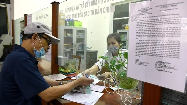 A local receives financial support from the VND62 trillion state support package at the People's Committee of Dien Bien Ward, Ba Dinh District, Hanoi, on April 30, 2020. (Photo: NDO/Duy Linh)