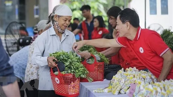 Residents in difficult circumstances shop at a humanitarian market hosted by the Vietnam Red Cross Society (Photo: VNA)