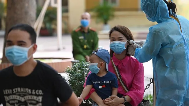 People wait for their turn to have sample taken for RT-PCR testing at the Nguyen Trai Secondary School in Hanoi's Ba Dinh District on August 8, 2020. (Photo: NDO/Duy Linh)