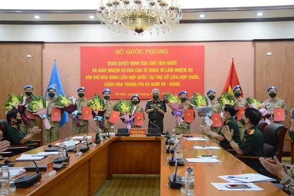 Sen. Lieut. Gen. Nguyen Chi Vinh hands over the President's decision to the 10 officers. (Photo: VNA)