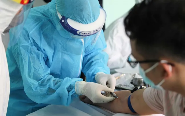 A health worker takes blood sample from a person to test for COVID-19. (Photo: VNA)