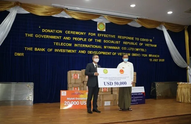 Vietnam Ambassador Ly Quoc Tuan (L) presents US$50,000 as a gift of the Vietnamese Government to Myanmar. (Photo: VOV)