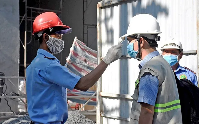 Workers have their body temperature measured before entering the construction site in Da Nang City.