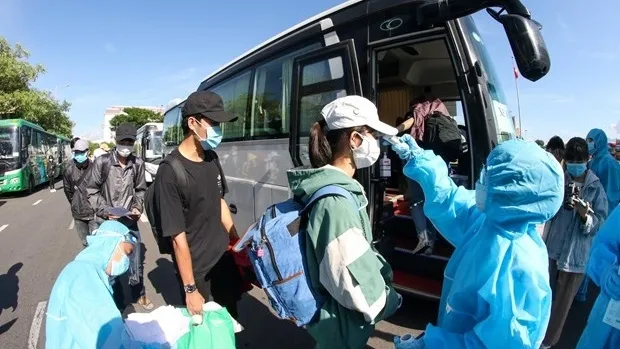 More than 700 people from the central province of Quang Ngai line up to board coaches heading home after finishing compulsory quarantine at a State-designed facility. (Photo: VNA)