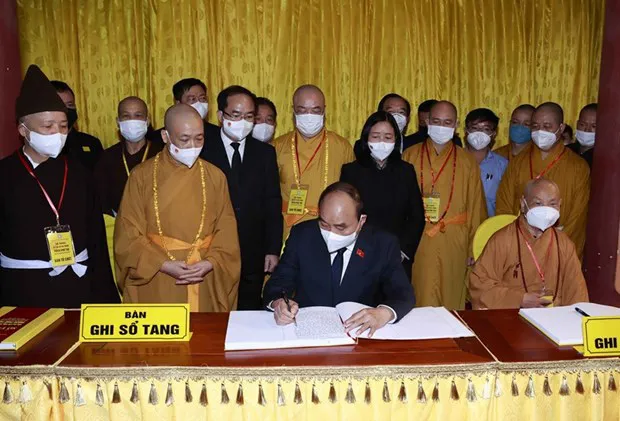 President Nguyen Xuan Phuc writes in the funeral guest book (Photo: VNA)