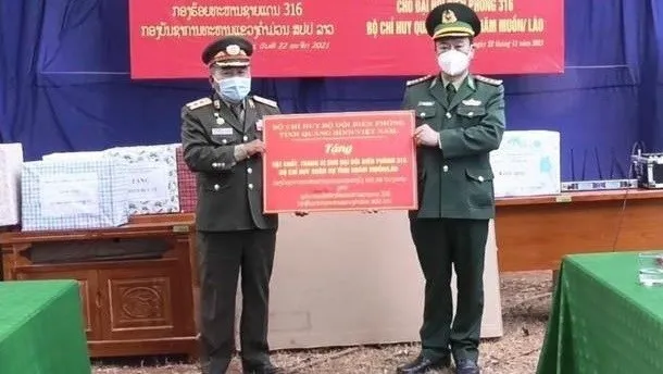 Colonel Trinh Thanh Binh (R), Commander of Quang Binh's Border Guard Command, presents medical supplies to an officer of Khammouane's border guard (Photo: VNA)