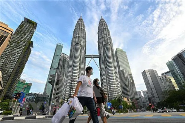 People seen wearing masks while walking the street in Kuala Lumpur, Malaysia. (Photo: Xinhua/VNA)
