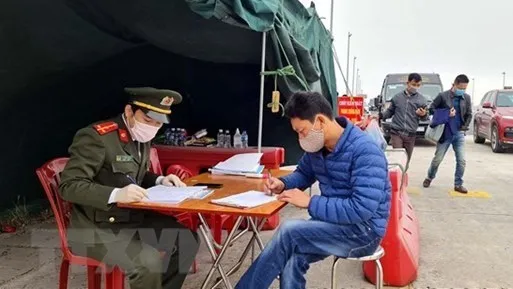 A man is filling in a health declaration at Bach Dang bridge station, Quang Yen township, Quang Ninh province (Photo: VNA)