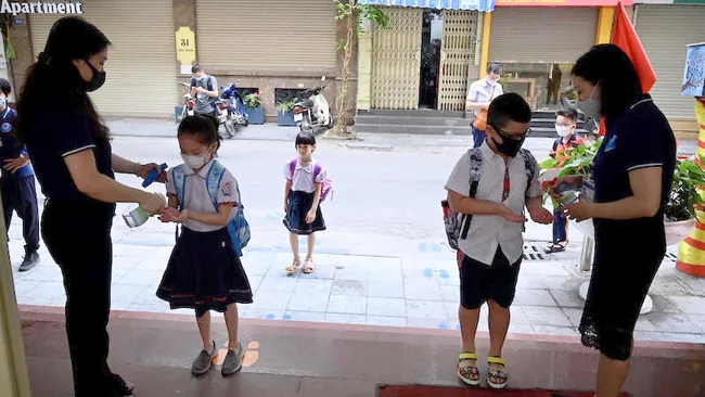 Students using hand sanitiser before entering school for classes. (Photo: NDO)