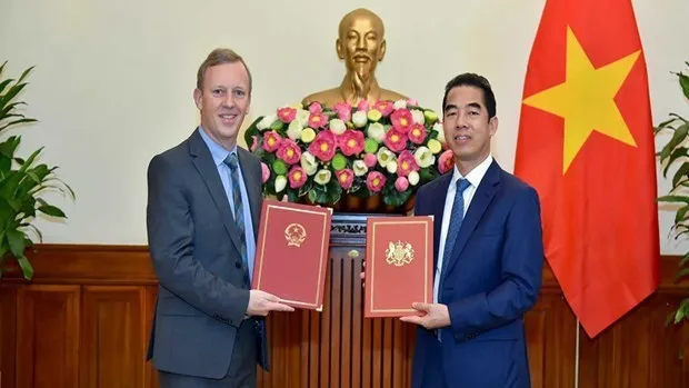 Deputy Minister of Foreign Affairs To Anh Dung (R) and UK Ambassador to Vietnam Gareth Ward (Photo: VNA)