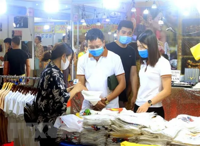 Visitors go shopping at booths at the event (Photo: VNA)