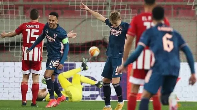 Arsenal's Martin Odegaard celebrates scoring their first goal with Pierre-Emerick Aubameyang as Olympiacos' Sokratis Papastathopoulos looks dejected. (Reuters)