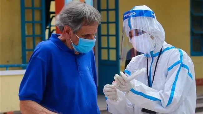 Collecting sample for COVID-19 testing of a foreigner. (Photo: VNA)