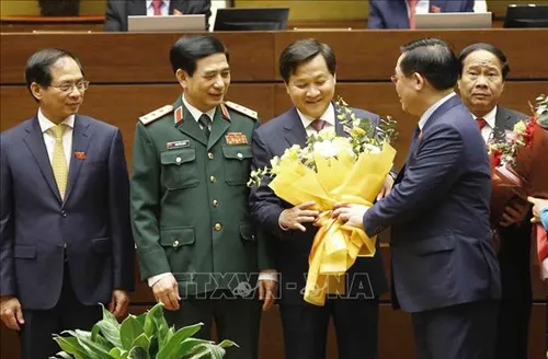 NA Chairman Vuong Dinh Hue presents flowers to newly-appointed Deputy PM Le Minh Khai (2nd from right).