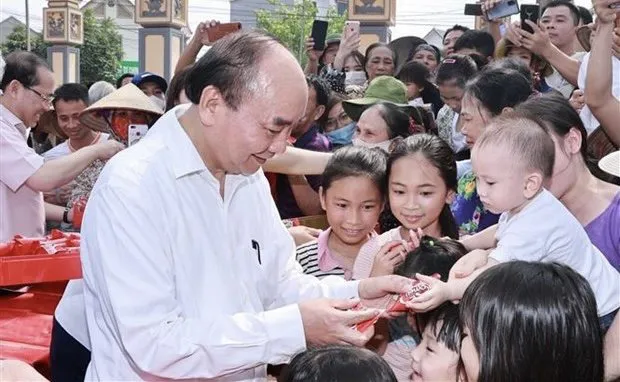 President Nguyen Xuan Phuc presents gifts to children in Tu Xa commune, Lam Thao district, Phu Tho province, on April 21. (Photo: VNA)