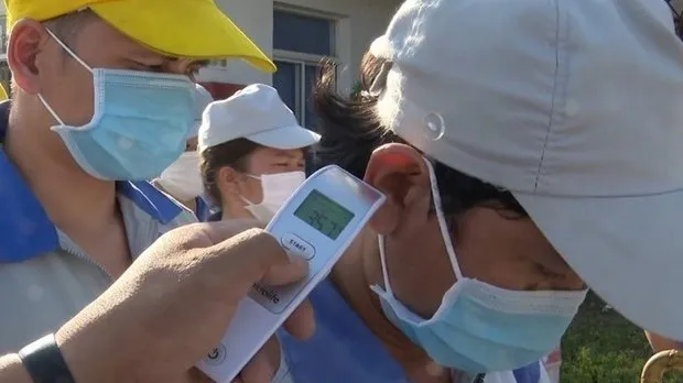 Taking body temperature of workers (Photo: VNA)