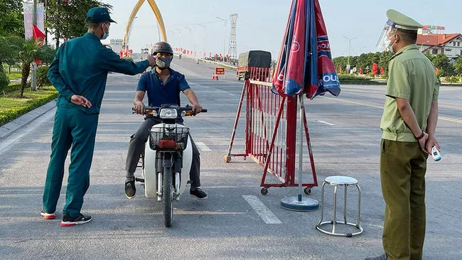 Checking body temperature of a local at a checkpoint in Bac Ninh City. (Photo: NDO)