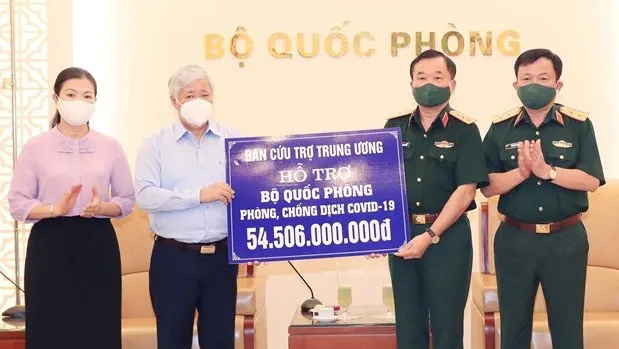 President of the VFF Central Committee Do Van Chien (second, left) symbolically presents the financial aid to Deputy Minister of National Defence Sen. Lt. Gen. Hoang Xuan Chien on May 24 (Photo: VNA)