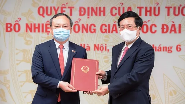 Deputy PM Pham Binh Minh presents the appointment decision to Do Tien Sy.