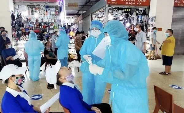 Medical workers take samples for COVID-19 testing from traders at Ha Long 1 Market in Quang Ninh province. (Photo: VNA)