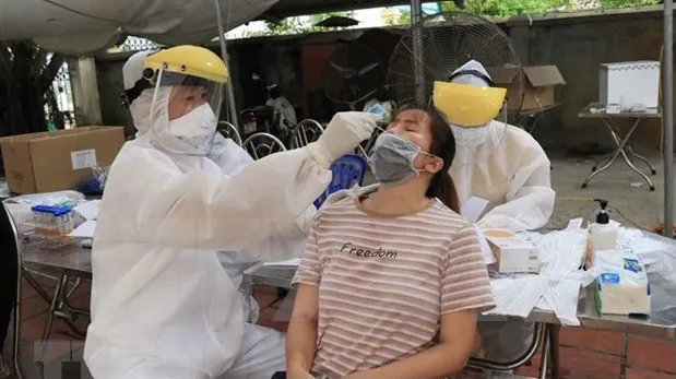 A medical worker takes samples from a woman in Bac Ninh for COVID-19 testing (Photo: VNA)