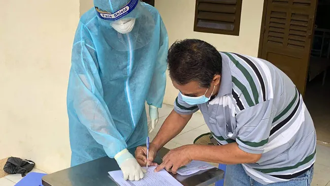 A man signs discharge papers at Ho Chi Minh City No. 1 Field Hospital. (Photo: DH)