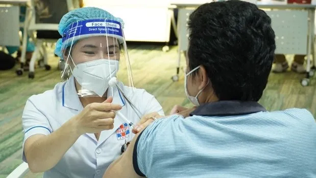 A medical worker gives a COVID-19 vaccine shot to a man in HCM City. (Photo: VNA)